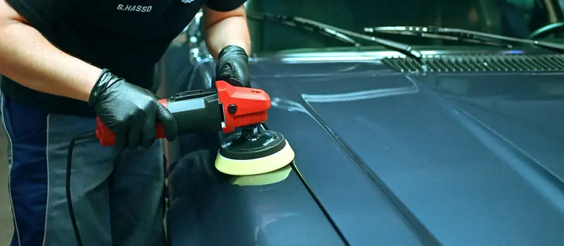 Detailer polishing a car bonnet