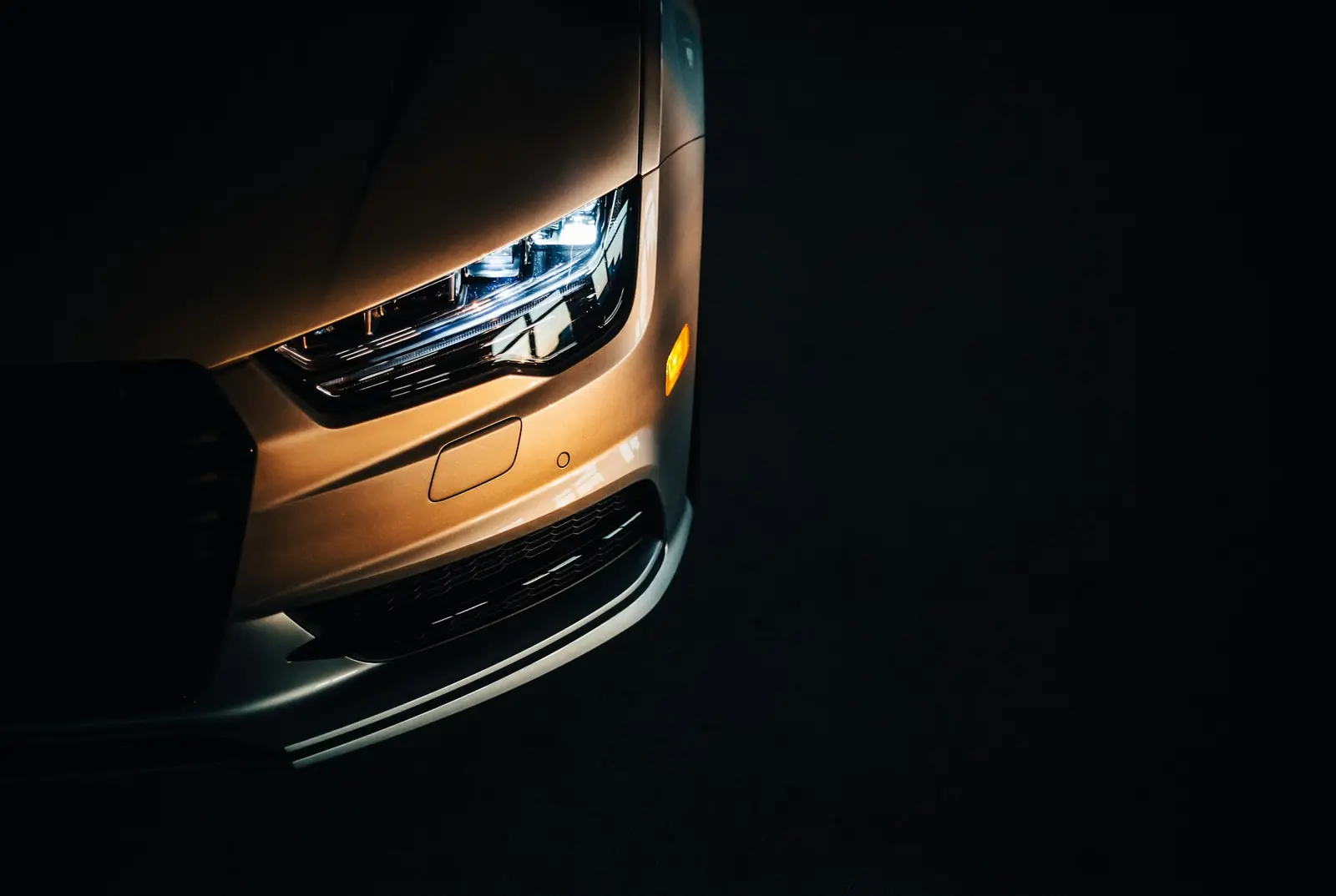 Close-up of a crystal-clear modern car headlight in the dark